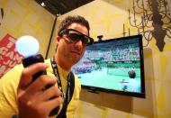 Pracownik Sony w okularach 3D prezentuje wykrywający ruchy kontroler do gier "Move"