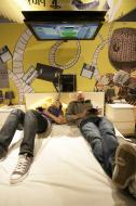Goście targów Gamescom grają na konsoli Playstation 3 z ekranem przyczepionym do sufitu